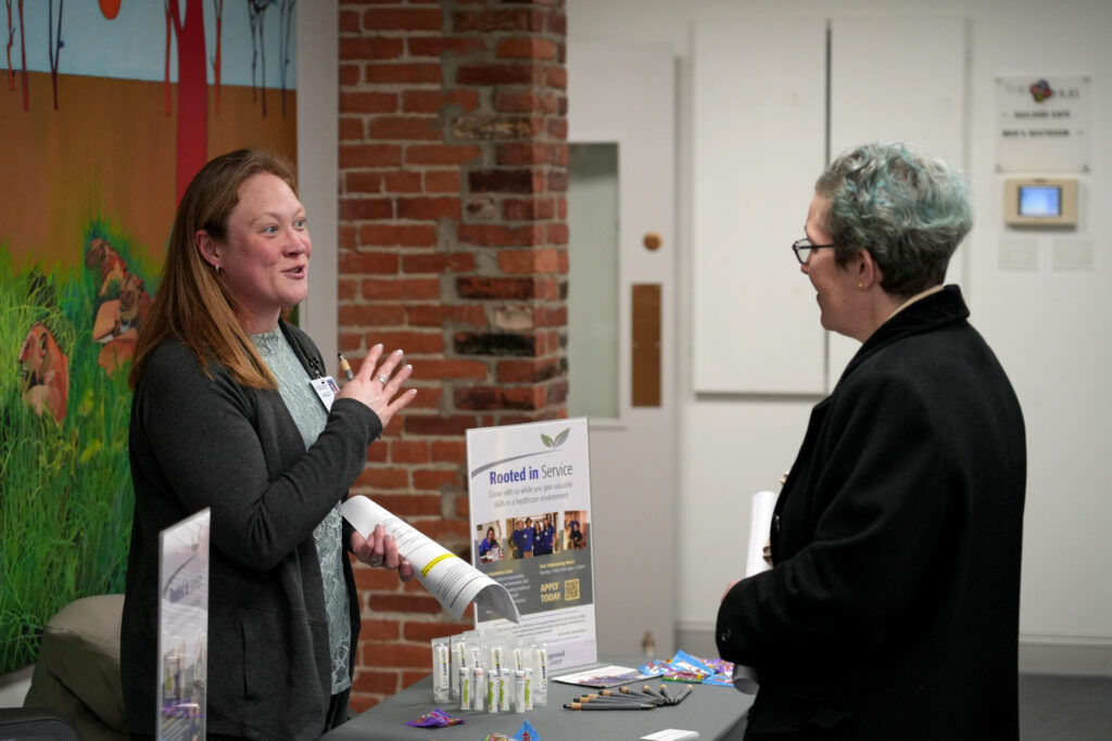 A presenter at the Real Rutland Community Roundup speaks with an attendee