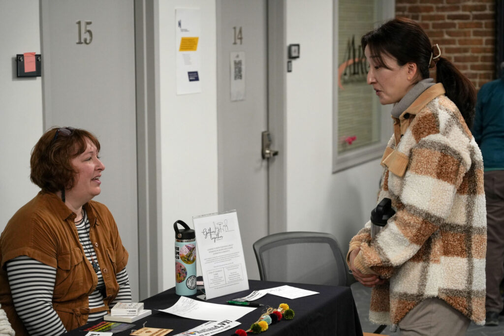 A presenter at the Real Rutland Community Roundup speaks with an attendee