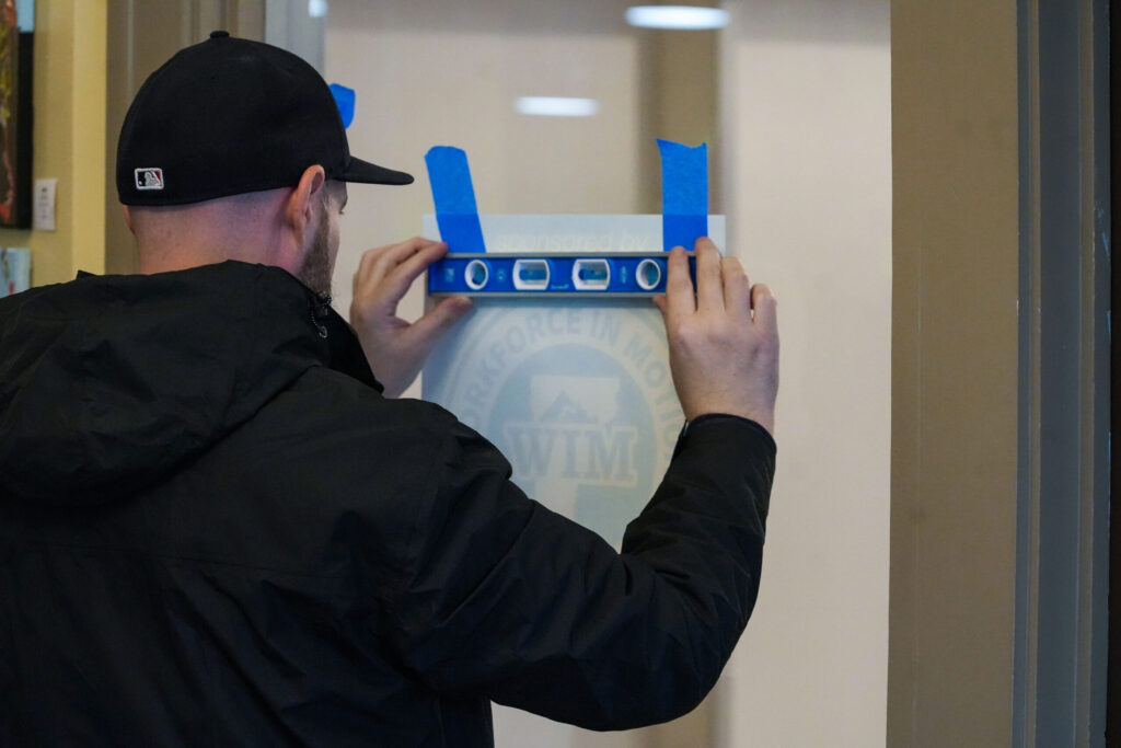 Tuttle Printing & Promotional Products installs graphics on the Workforce in Motion Streetside Conference Center at The Hub CoWorks.