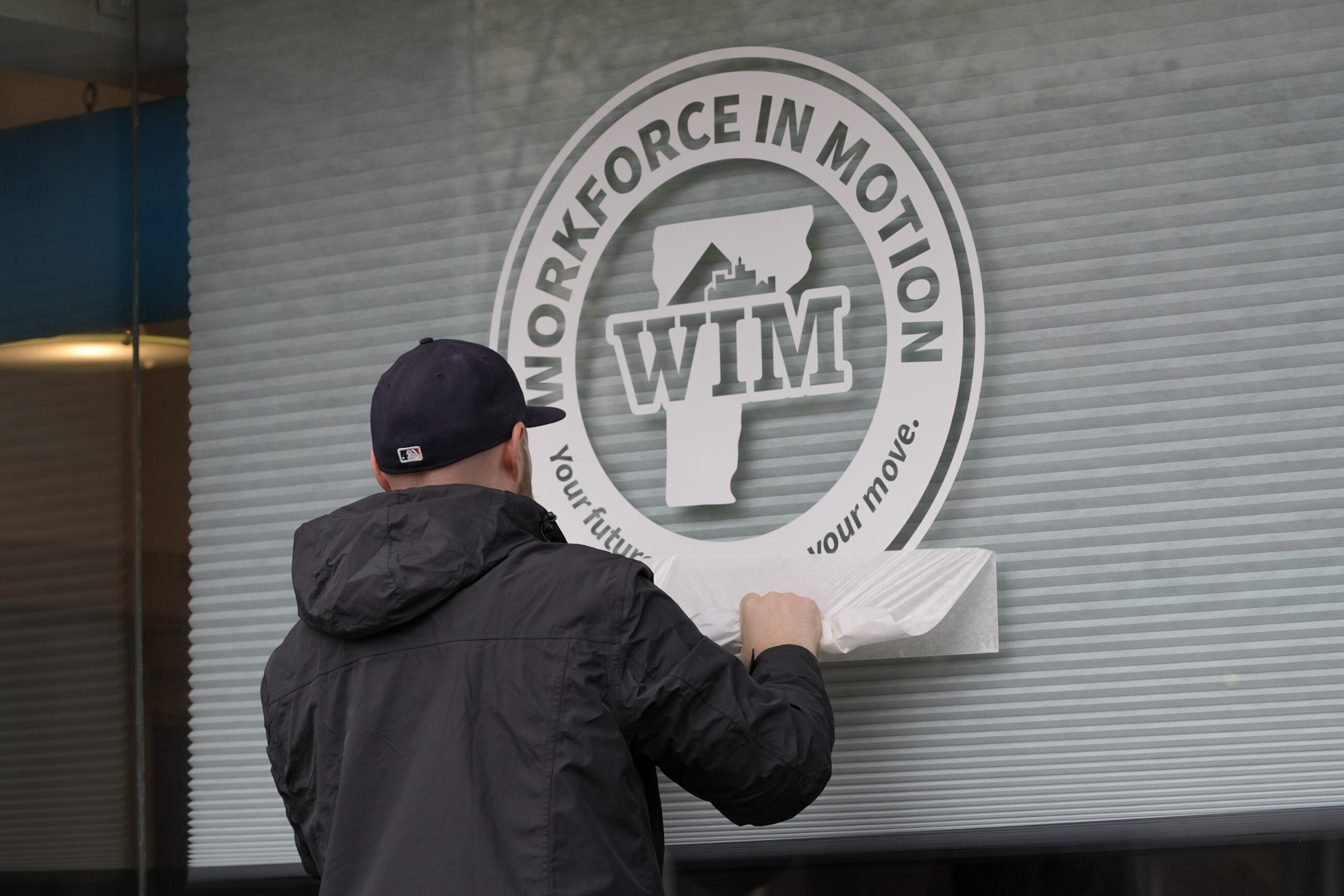 Tuttle Printing & Promotional Products installs graphics on the Workforce in Motion Streetside Conference Center at The Hub CoWorks.